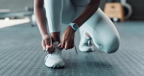 Person Ties Athletic Shoes Before Workout