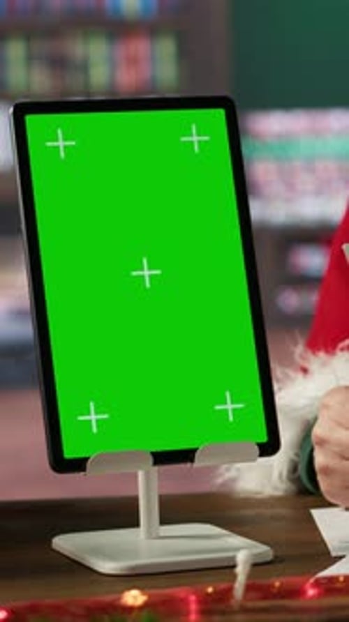 Vertical Video Father Christmas Looking at His Naughty or Nice List Next to Isolated Screen