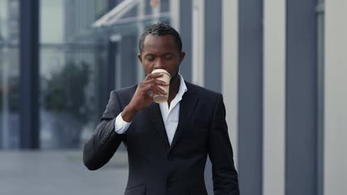 Man Checks Watch and Drinks Coffee Outdoors