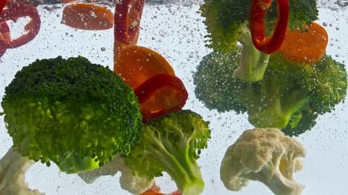Raw Delicious Vegetables Dropped Transparent Water on White Background Closeup. Organic Healthy