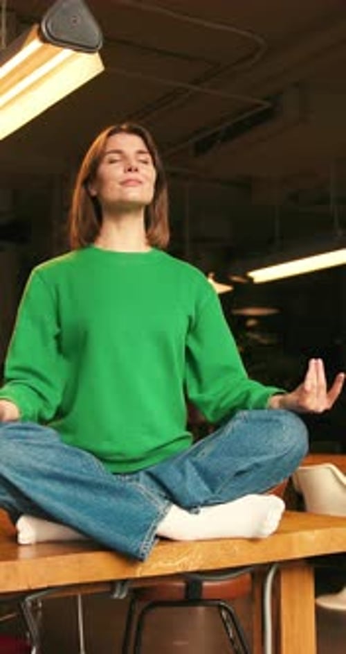 Woman Meditating on Desk in Modern Office