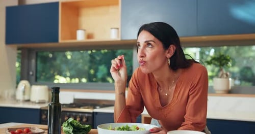 Woman Enjoys Salad in Modern Kitchen