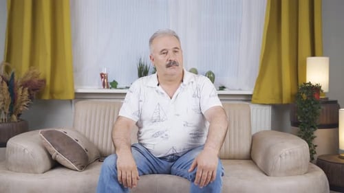 Man Sitting on Sofa Inside Living Room