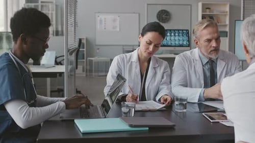 Medical Professionals Collaborating at Conference Table in Office