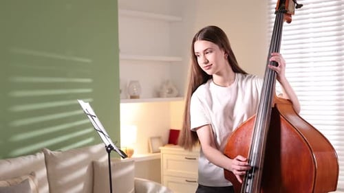 Young Woman Practices Double Bass in Living Room