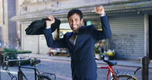 A businessman dancing in the square and is glad to have received a promotion or winning a bet. Con