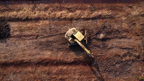 Excavator dig ground at construction site. Aerial view of a wheel loader excavator with a backhoe
