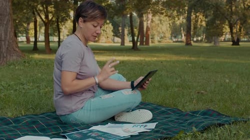 Woman Video Calling in Grassy City Park