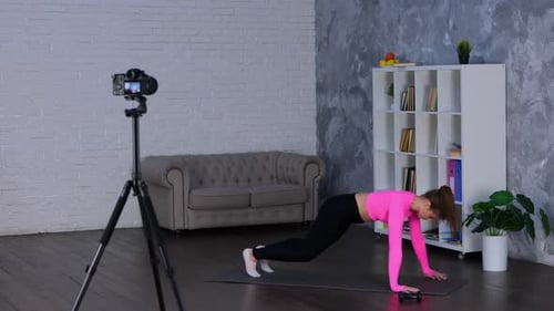 Jeune femme portant des vêtements de sport et faisant de l'entraînement par intervalles à haute intensité faisant du Jumping Burpee Home