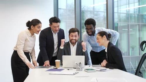 Colleagues Celebrate Success Around Laptop in Office