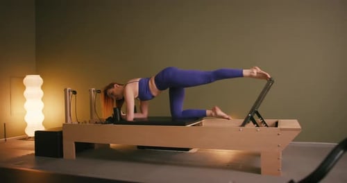Woman Doing Leg Extensions on Pilates Reformer