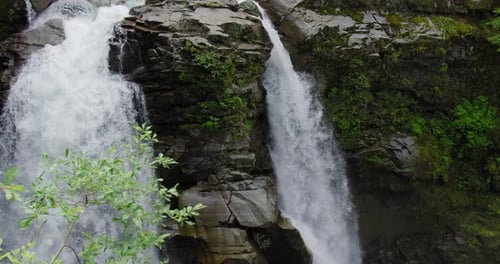 Forest Waterfall. Slow Motion Of Natural Stream Of Water Flowing Through Rocks From A Height. tilt d