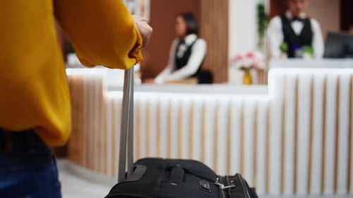 Asian Traveler Asking Receptionist About Hotel Facilities