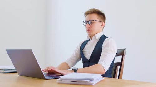 Fair-Haired Man Typing, Stretching Back at Desk