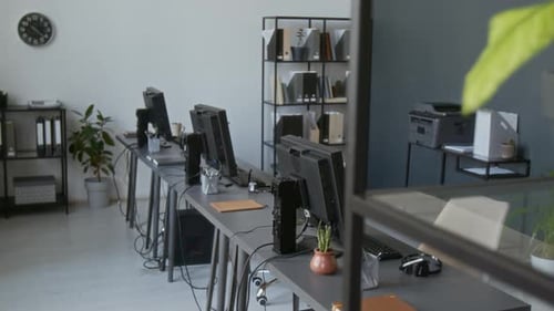 Office Space with Multiple Desks Lined up and Equipped with Computer Monitors