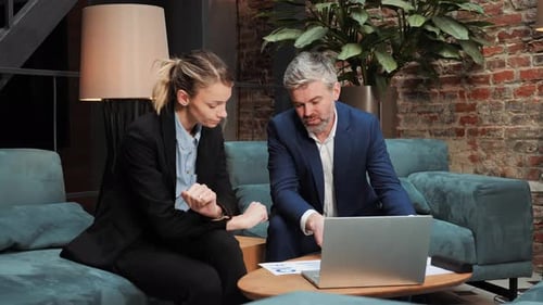 Colleagues Discussing Data on Laptop in Office