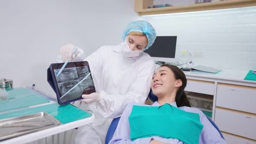 Dentist explain oral care from teeth x-ray to patient at dental clinic.