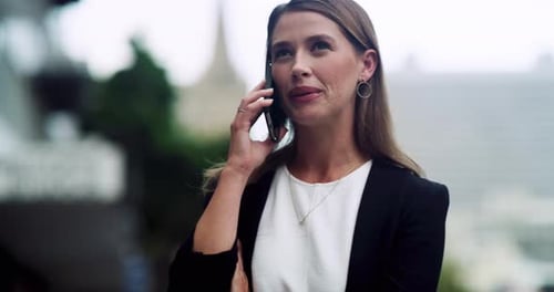 4k video footage of a well dressed corporate businesswoman making a phonecall while in the city