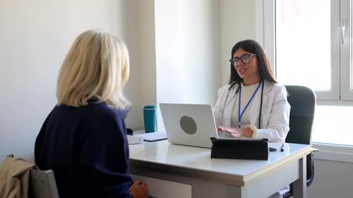 Female doctor consulting with patient in clinic office
