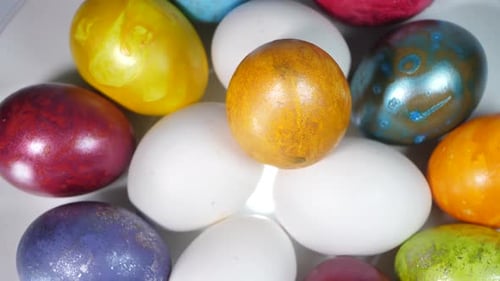 Colored eggs rotate in a basket. Easter eggs in all colors