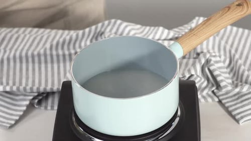 Adding Water and Sugar Into a Saucepan