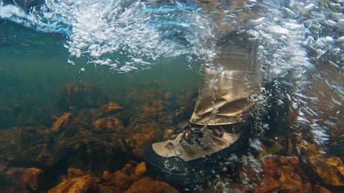 Angler Walks in the River in Wading Boots