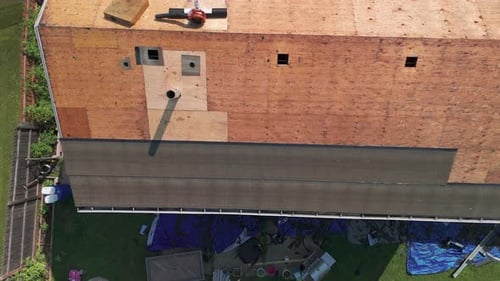Roofers Installing a New Roof on an Residential Building Wide Drone Top Down Footage