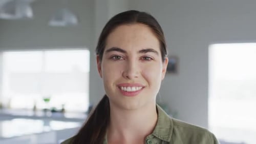 Portrait of happy caucasian woman looking at camera at home