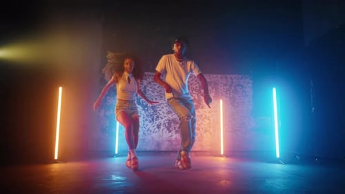 Positive Male and Female Dancers Moving Actively on Dance Floor in Studio Fulllength Portrait of