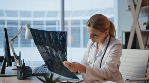 Thoughtful Doctor Analyzing Xray in Medical Office Closeup Woman Looking Scan