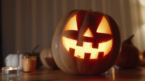 Halloween Pumpkins on the Table, Home Setting in the Dark by Candlelight. Slider.