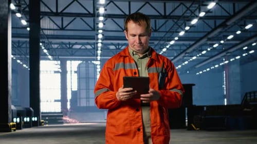 Industrial Supervisor Monitoring Equipment Near a Workshop Station