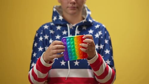 Young Adult Plays With Multicolored Fidget Toy