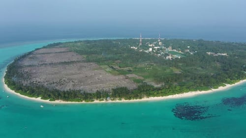 Aerial view of island beach with turquoise water and lush forest, Maldives.