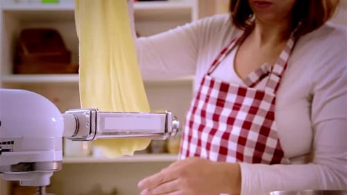 Woman Making Fresh Pasta Dough with Pasta Machine