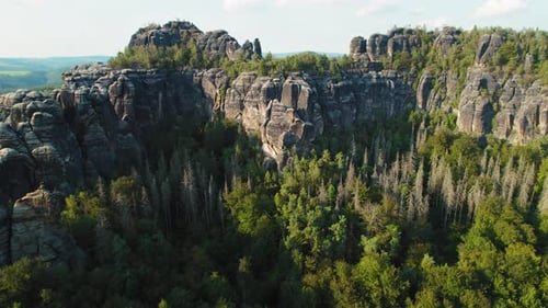 Aerial view of rocky cliffs and green forests in Schrammsteine Elbe Sandstone Mountains under the af