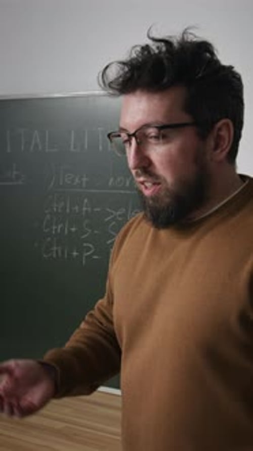 Male Teacher Pointing at Board in Computer Class Vertical