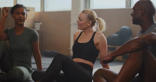 Mit Freunden und Lachen beim Zusammensitzen auf einem Fitnessboden nach einer Trainingsstunde Junge...