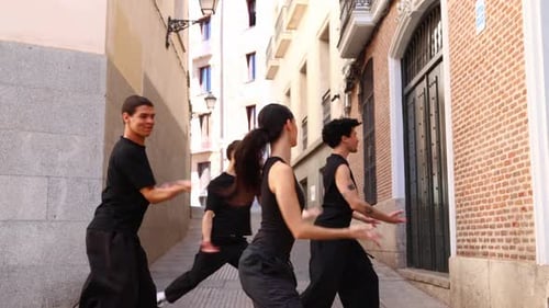 Group of Professional Dancers Performing Contemporary Choreography in an Urban Alley