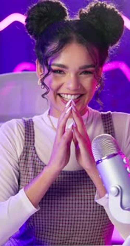 Podcast, woman and happy with microphone on neon background for live streaming or social media