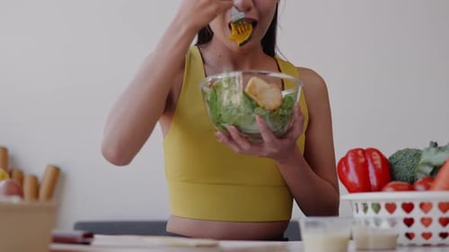 Woman Eating Healthy Salad in Bright Kitchen