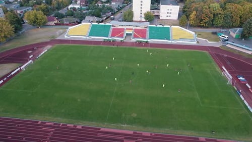 Shooting From a Quadcopter of a Football Game at a City Stadium with Treadmills and Colorful Empty