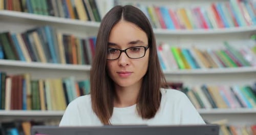 Young Woman Works on Laptop in Library