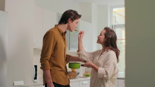 Loving Couple Cooking and Tasting Food Together