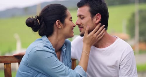 4k video footage of a young couple sharing a romantic moment on a park bench