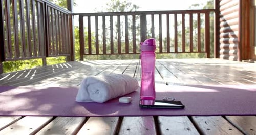 Yoga Mat with Fitness Essentials on Wooden Deck