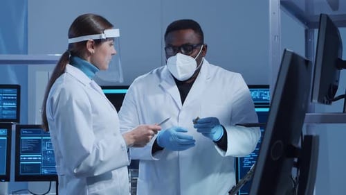 Scientists Inspecting Electronic Component in Bright Lab