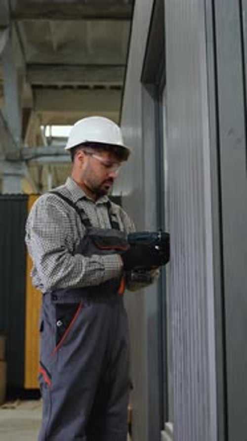 Construction Worker Using Cordless Screwdriver in Factory