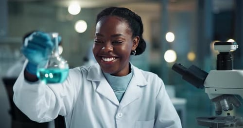 Woman Scientist Analyzes Flask And Uses Microscope