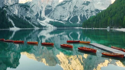 Volando sobre las tranquilas aguas de color verde esmeralda del lago Braies, revelando los Dolomitas de Prags, desde el aire
